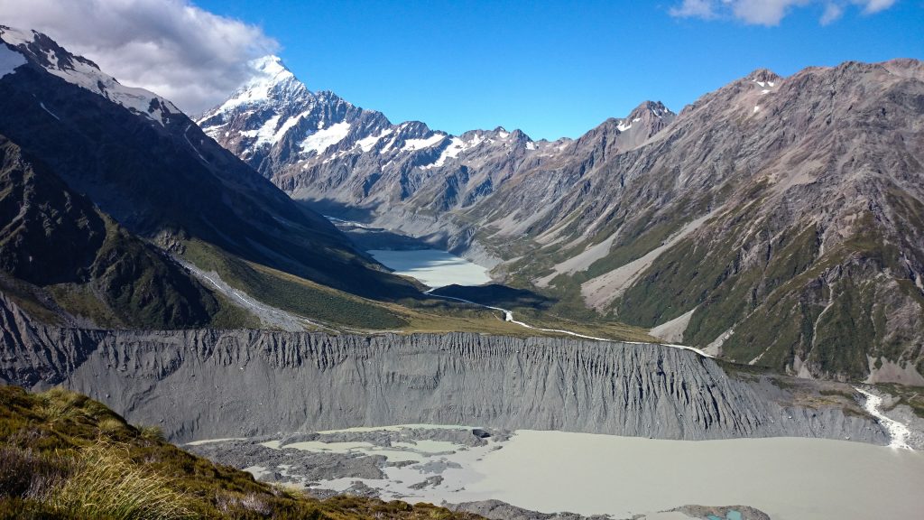 Wanderungen im Mount Cook Nationalpark, Aoraki, Südinsel Neuseeland, Wanderung zum Kea Point Track mit Sonnenschein, schneebedeckte Gipfel in der Ferne, raue, lebensfeindliche und doch wunderschöne Umgebung, Sonnenschein, schlammiges Gletscherwasser