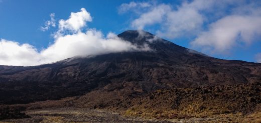 Tongariro Alpine Crossing Wanderung, Nordinsel Neuseeland, Vulkanlandschaft, lebensfeindliche Landschaft, in Wolken gehüllte Berge, Geröll und Steine, Vulkan Gipfel, mystisch