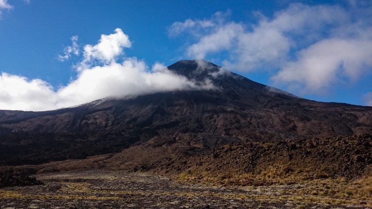Tongariro Alpine Crossing Wanderung, Nordinsel Neuseeland, Vulkanlandschaft, lebensfeindliche Landschaft, in Wolken gehüllte Berge, Geröll und Steine, Vulkan Gipfel, mystisch