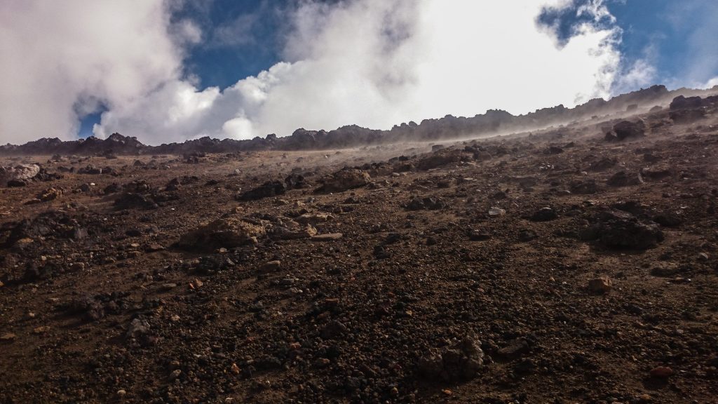 Tongariro Alpine Crossing Wanderung, Nordinsel Neuseeland, Vulkanlandschaft, lebensfeindliche Landschaft, in Wolken gehüllte Berge, Geröll und Steine