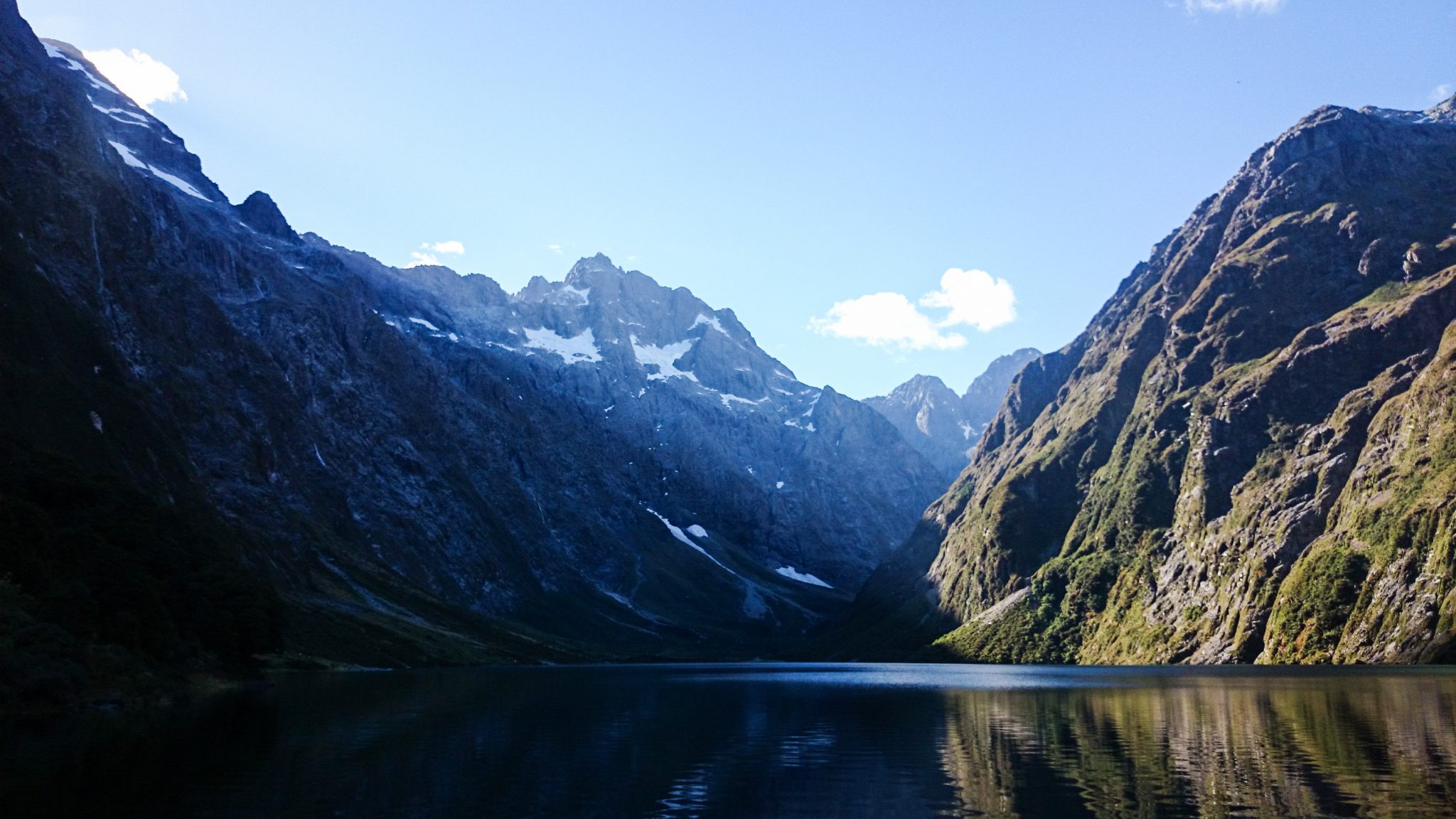 Lake Marian Track wandern, bei Marian Falls im Fiordland National Park Südinsel Neuseelands, Wanderung zum See Marian, Lake Marian, Tal, hanging valley, schneebedeckte Gipfel in der Ferne, Berge spiegeln sich im klaren Wasser, schönes Licht, Sonne, Steine