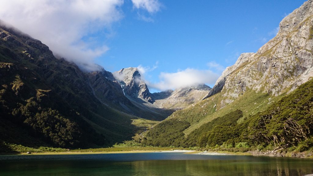 Wanderung Routeburn Track - Great Walk im Fiordland Nationalpark Südinsel Neuseeland, Wanderweg Routeburn im Fiordland Nationalpark, beeindruckende Berge mit schneebedeckten Gipfeln über der Baumgrenze, herrlicher Sommertag auf Südinsel Neuseelands, traumhafte Wanderung, raues Gebirgsklima, lebensfeindlich und doch wunderschön, beeindruckend, schöner Gebirgssee mit klarem Wasser, Umgebung spiegelt sich