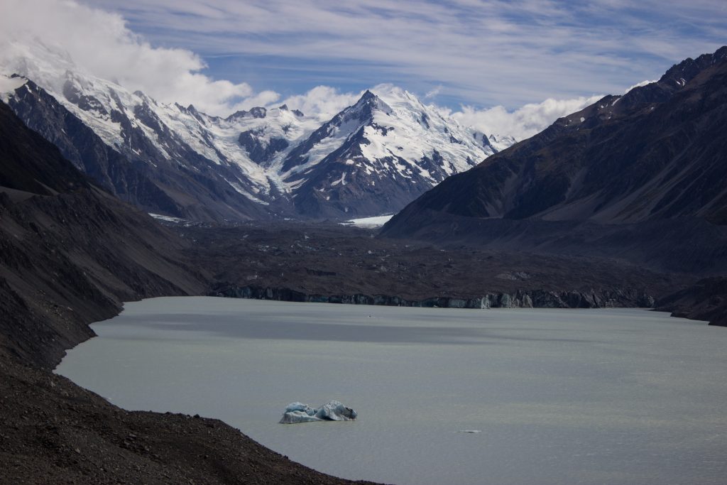 Wanderungen im Mount Cook Nationalpark, Aoraki, Südinsel Neuseeland, Wanderung zum Tasman Glacier View, schwimmender kleiner Eisberg im Gletschersee, schneebedeckte Gipfel in der Ferne, raue, lebensfeindliche und doch wunderschöne Umgebung