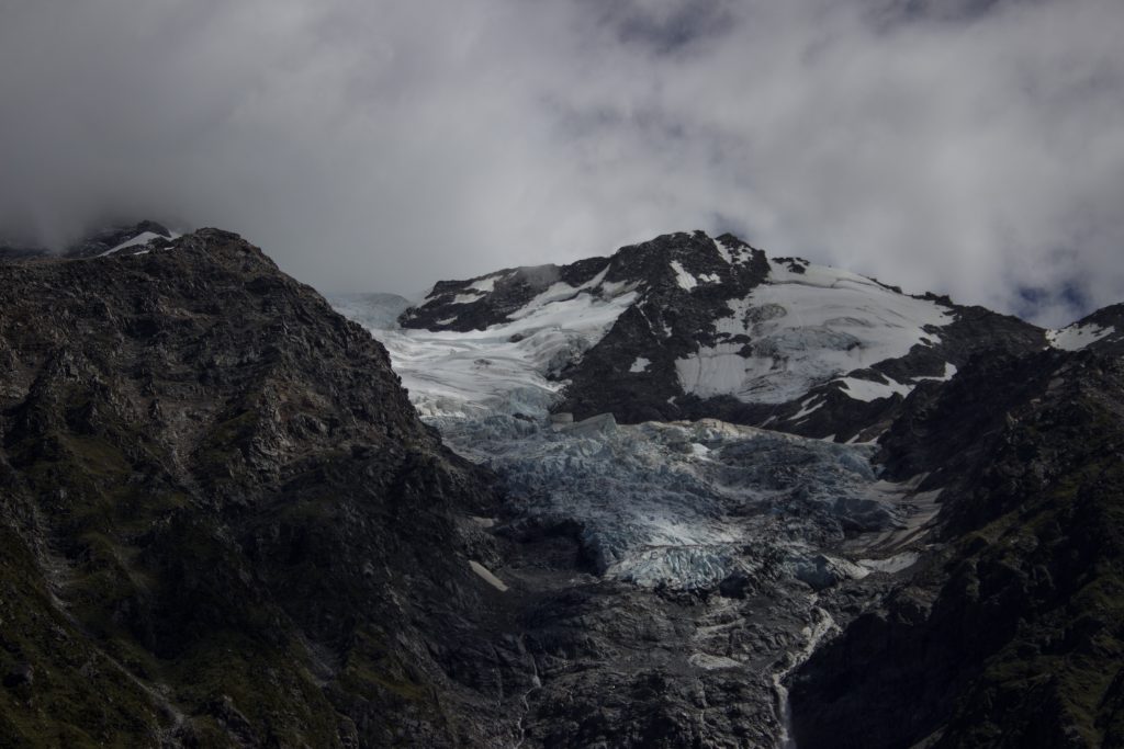 Wanderungen im Mount Cook Nationalpark, Aoraki, Südinsel Neuseeland, Wanderung im Hooker Valley mit Sonnenschein an zauberhaftem Tag in Neuseeland auf der Südinsel, schneebedeckte Gipfel in der Ferne, raue, lebensfeindliche und doch wunderschöne Umgebung