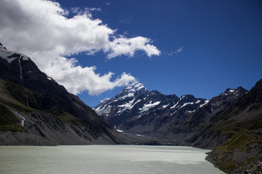 Wanderungen im Mount Cook Nationalpark, Aoraki, Südinsel Neuseeland, Wanderung im Mount Cook Nationalpark mit Sonnenschein, schneebedeckte Gipfel in der Ferne, raue, lebensfeindliche und doch wunderschöne Umgebung, Sonnenschein, schlammiges Gletscherwasser