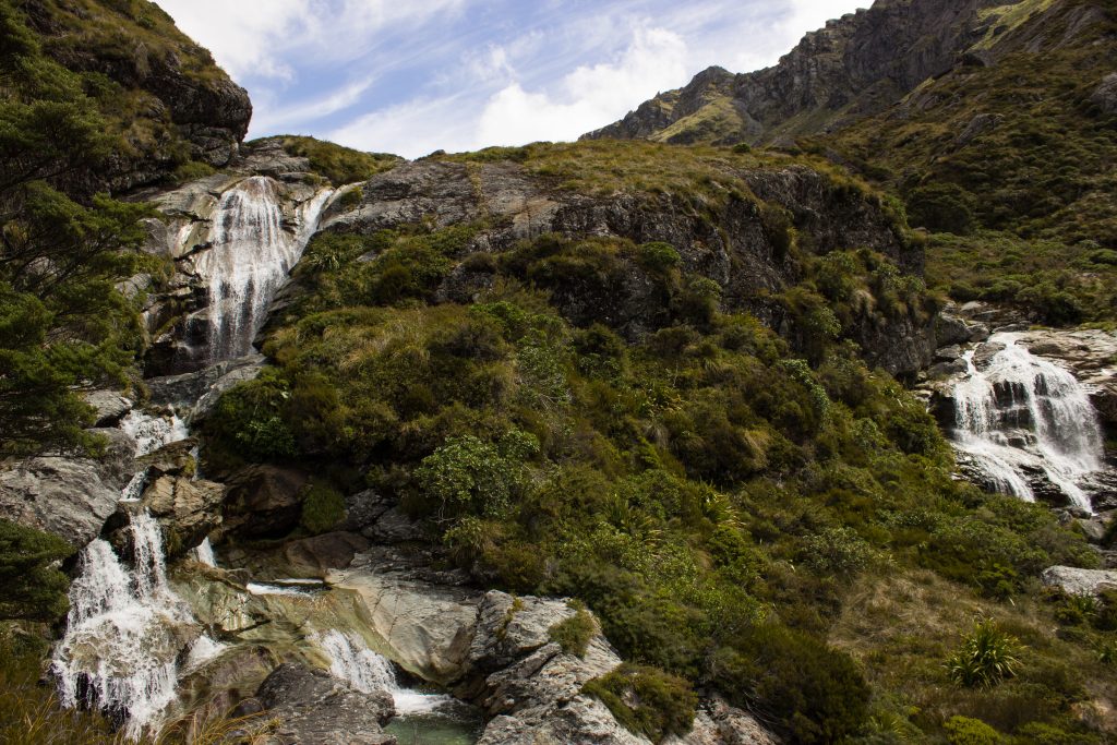 Wanderung Routeburn Track - Great Walk im Fiordland Nationalpark Südinsel Neuseeland, Wanderweg Routeburn im Fiordland Nationalpark, beeindruckende Berge mit schneebedeckten Gipfeln über der Baumgrenze, herrlicher Sommertag auf Südinsel Neuseelands, traumhafte Wanderung, raues Gebirgsklima, lebensfeindlich und doch wunderschön, beeindruckend, Wasserfall