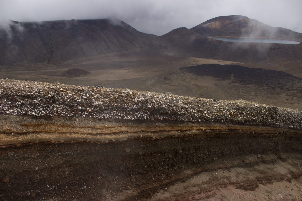 Tongariro Alpine Crossing Wanderung, Nordinsel Neuseeland, Vulkanlandschaft, lebensfeindliche Landschaft, in Wolken gehüllte Berge, Geröll und Steine