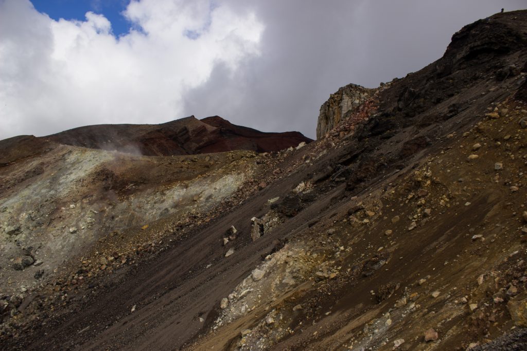 Tongariro Alpine Crossing Wanderung, Nordinsel Neuseeland, Vulkanlandschaft, lebensfeindliche Landschaft, in Wolken gehüllte Berge, Geröll und Steine