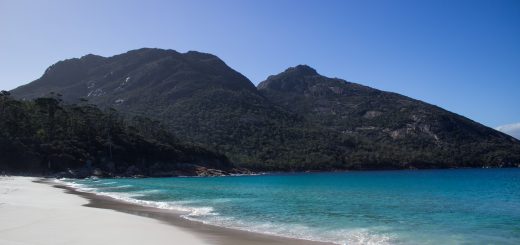 Wineglass Bay, Bucht im traumhaften Freycinet Nationalpark in Tasmanien, saftig grüner Wald, Berge, Strand mit schneeweißem Zuckersand und kristallklarem Wasser, Traumstrand