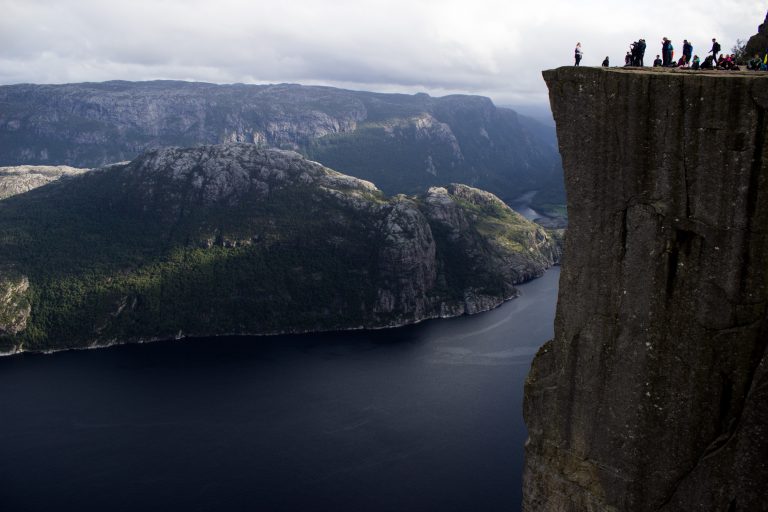 Wanderung zum Pulpit Rock Preikestolen, berühmtester Felsen in Norwegen, Blick auf Pulpit Rock, riesige steile Felswand mit Wanderern, 600 Meter darunter Lysefjord, traumhafte Landschaft