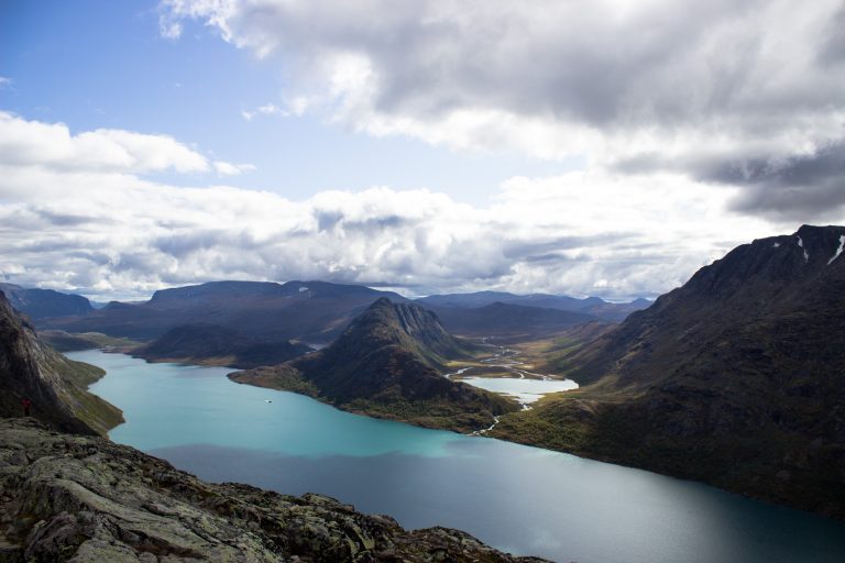 Wanderung Besseggen-Grat im Jotunheimen Nationalpark, Aussicht auf wunderschönen Gjendesee und umgebende Berge, Sonne zaubert traumhafte Farben