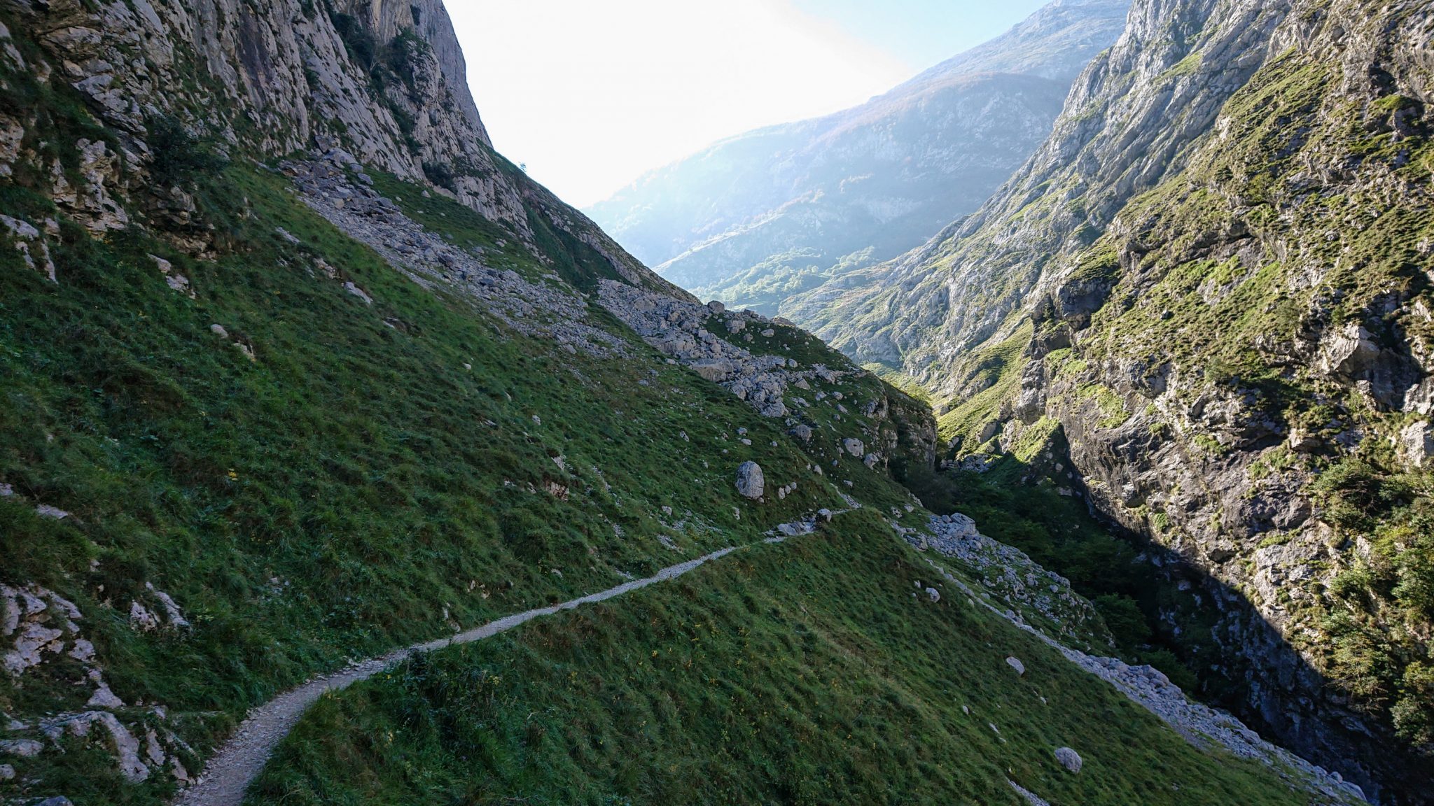 Wanderung Poncebos nach Bulnes in den Picos de Europa, schmaler Wanderpfad zwischen hohen Felswänden, saftig grüne Wiese, Steine und Geröll, tolles Wanderwetter