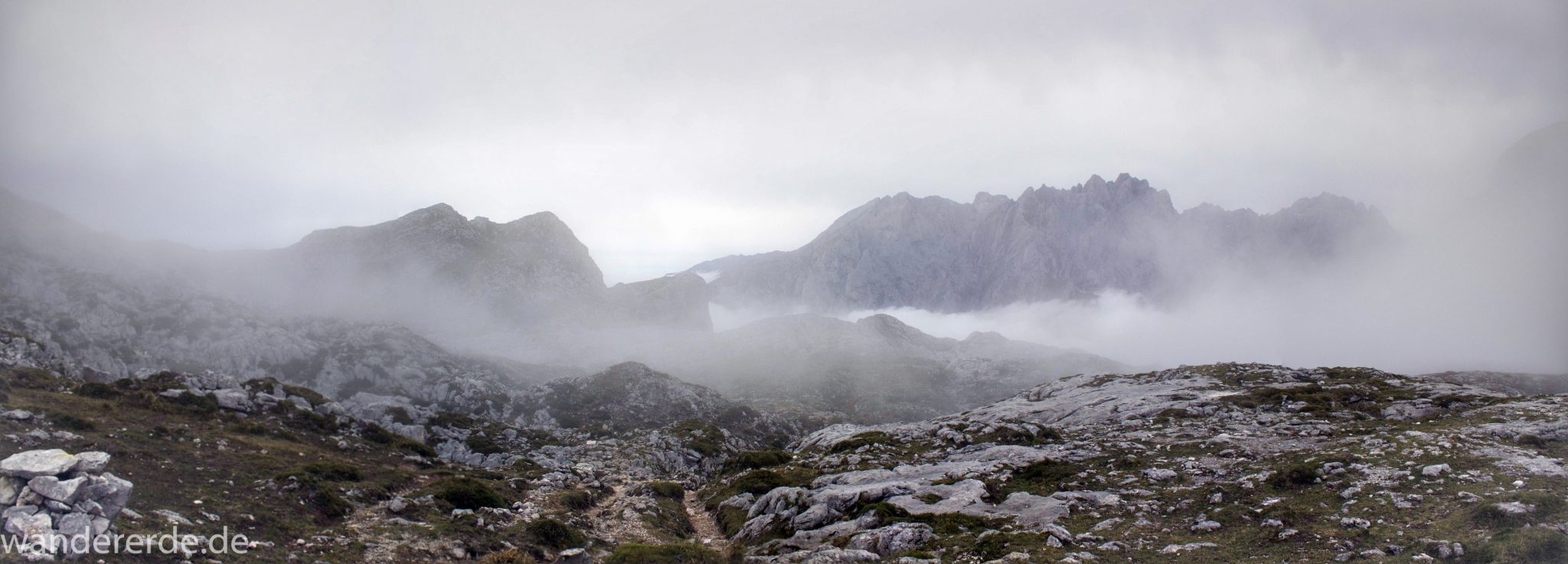 Wanderung Vega de Ario Picos de Europa Spanien, dichte Wolken, Bergregion in Nordspanien, Wandern, zerklüftete Felsen, Steine, schmaler Wanderpfad, Berge in Wolken, atmosphärisch