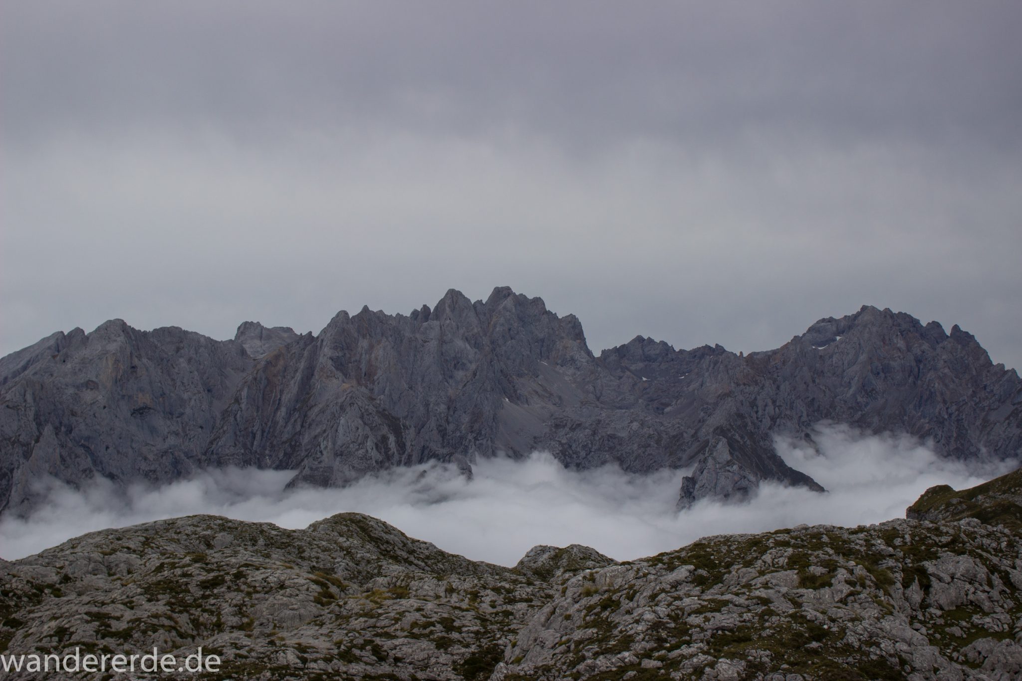 Wanderung Vega de Ario Picos de Europa Spanien, dichte Wolken, Bergregion in Nordspanien, Wandern, zerklüftete Felsen, Steine, schmaler Wanderpfad, atmosphärisch, Aussicht auf große Bergkette