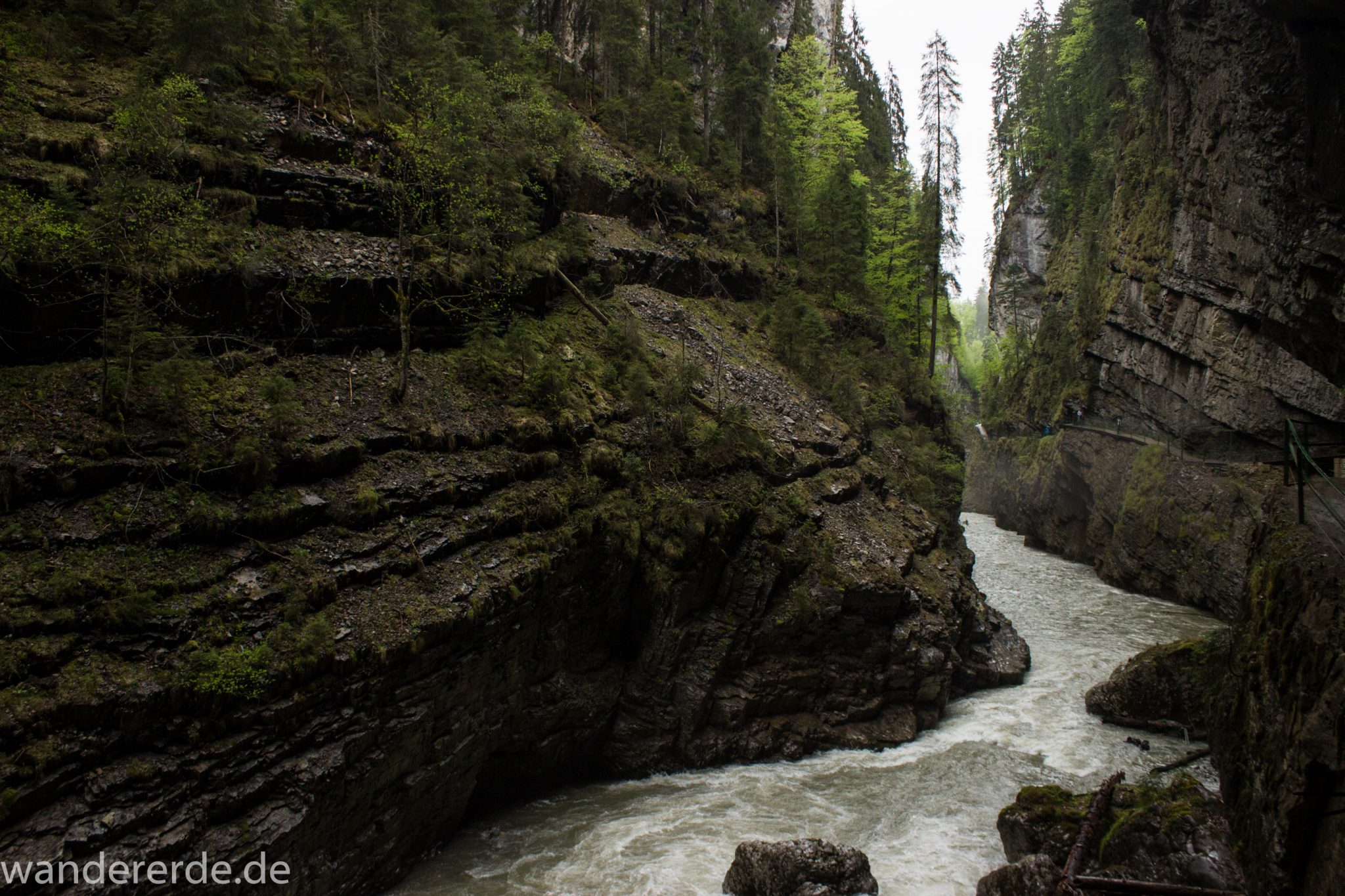 Wanderung durch die Breitachklamm im Allgäu, sehr hohe Felswände, tosende Breitach nach starkem Regen, Klamm umgeben von schönem Wald, Felsen im Fluss, Schneeschmelze im Allgäu, Wanderweg durch die Klamm