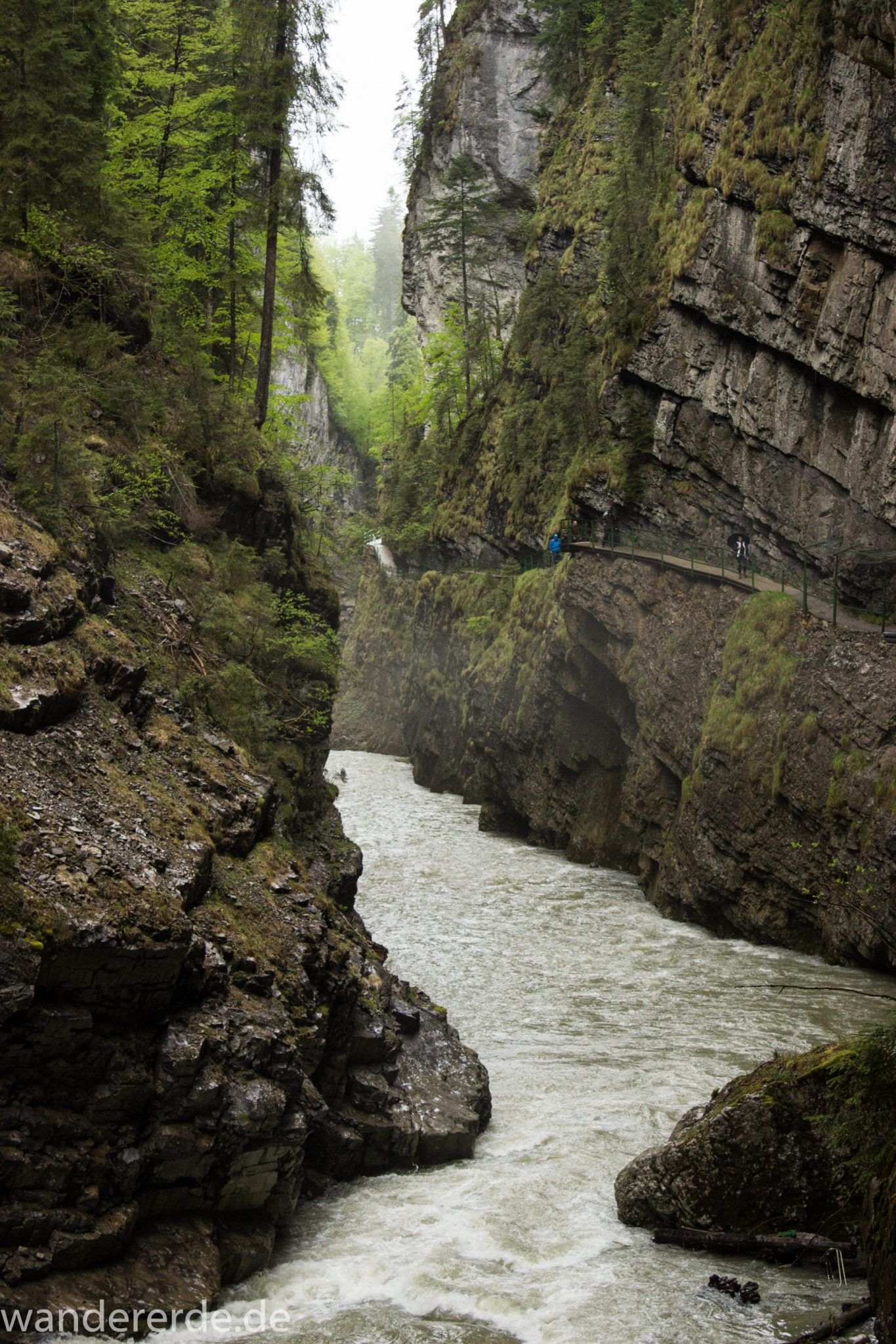 Wanderung durch die Breitachklamm im Allgäu, sehr hohe Felswände, tosende Breitach nach starkem Regen, Klamm umgeben von schönem Wald, Felsen im Fluss, Schneeschmelze im Allgäu, Wanderweg durch die Klamm