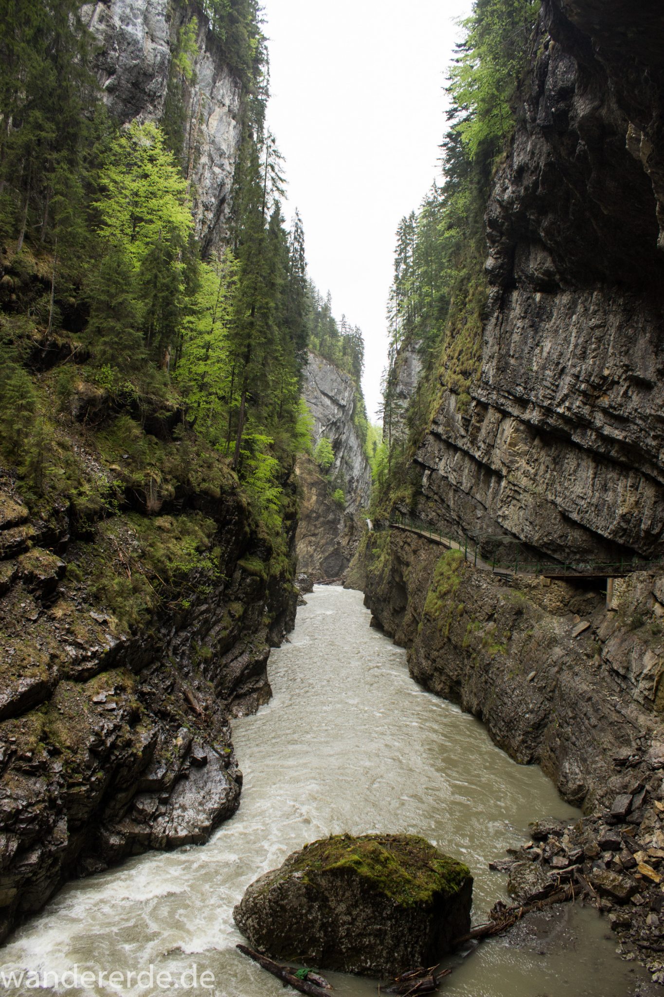 Wanderung durch die Breitachklamm im Allgäu, sehr hohe Felswände, tosende Breitach nach starkem Regen, Klamm umgeben von schönem Wald, Felsen im Fluss, Schneeschmelze im Allgäu, Wanderweg durch die Klamm