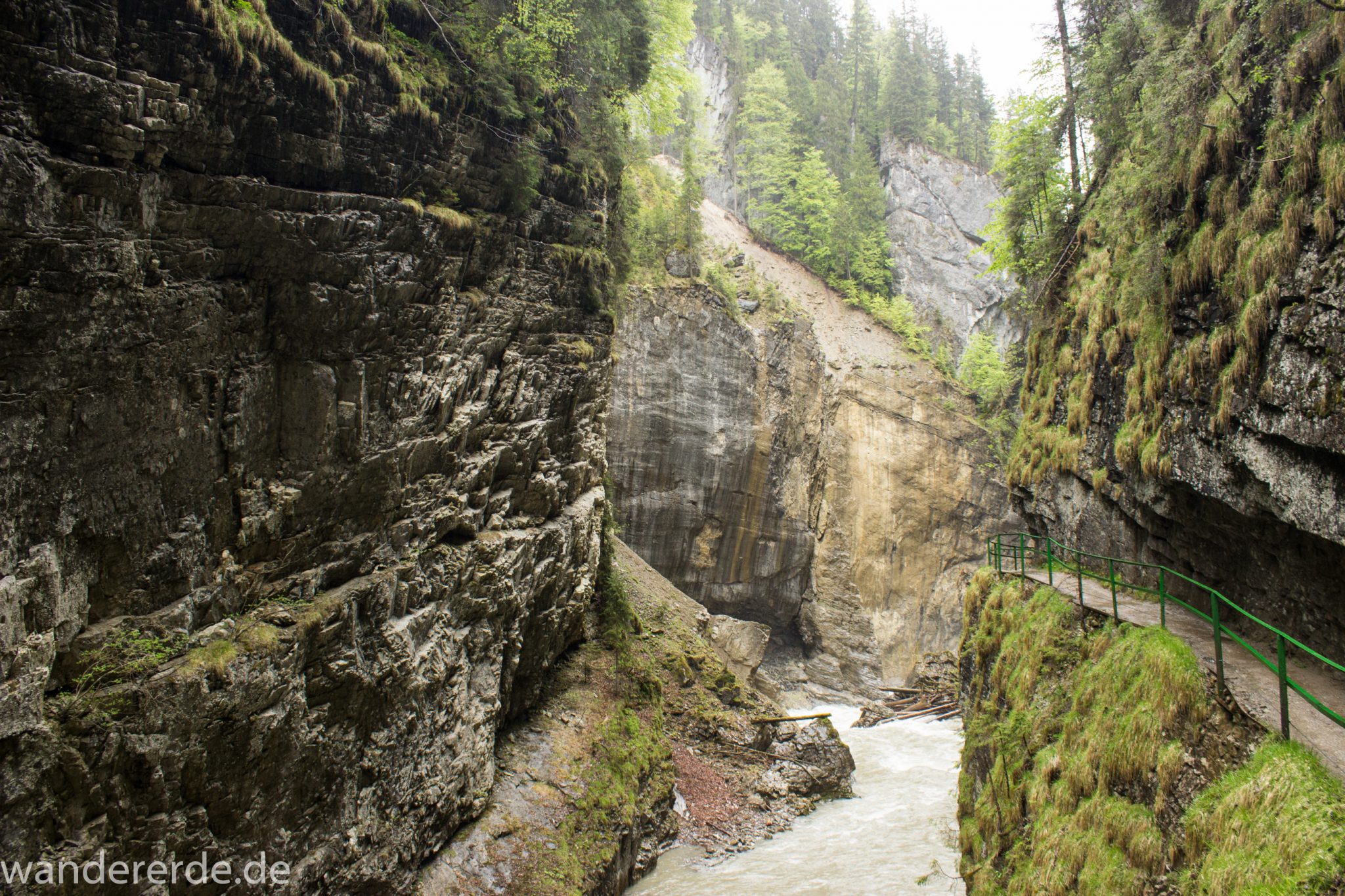Wanderung durch die Breitachklamm im Allgäu, sehr hohe Felswände, tosende Breitach nach starkem Regen, Klamm umgeben von schönem Wald, Felsen im Fluss, Schneeschmelze im Allgäu, Wanderweg durch die Klamm