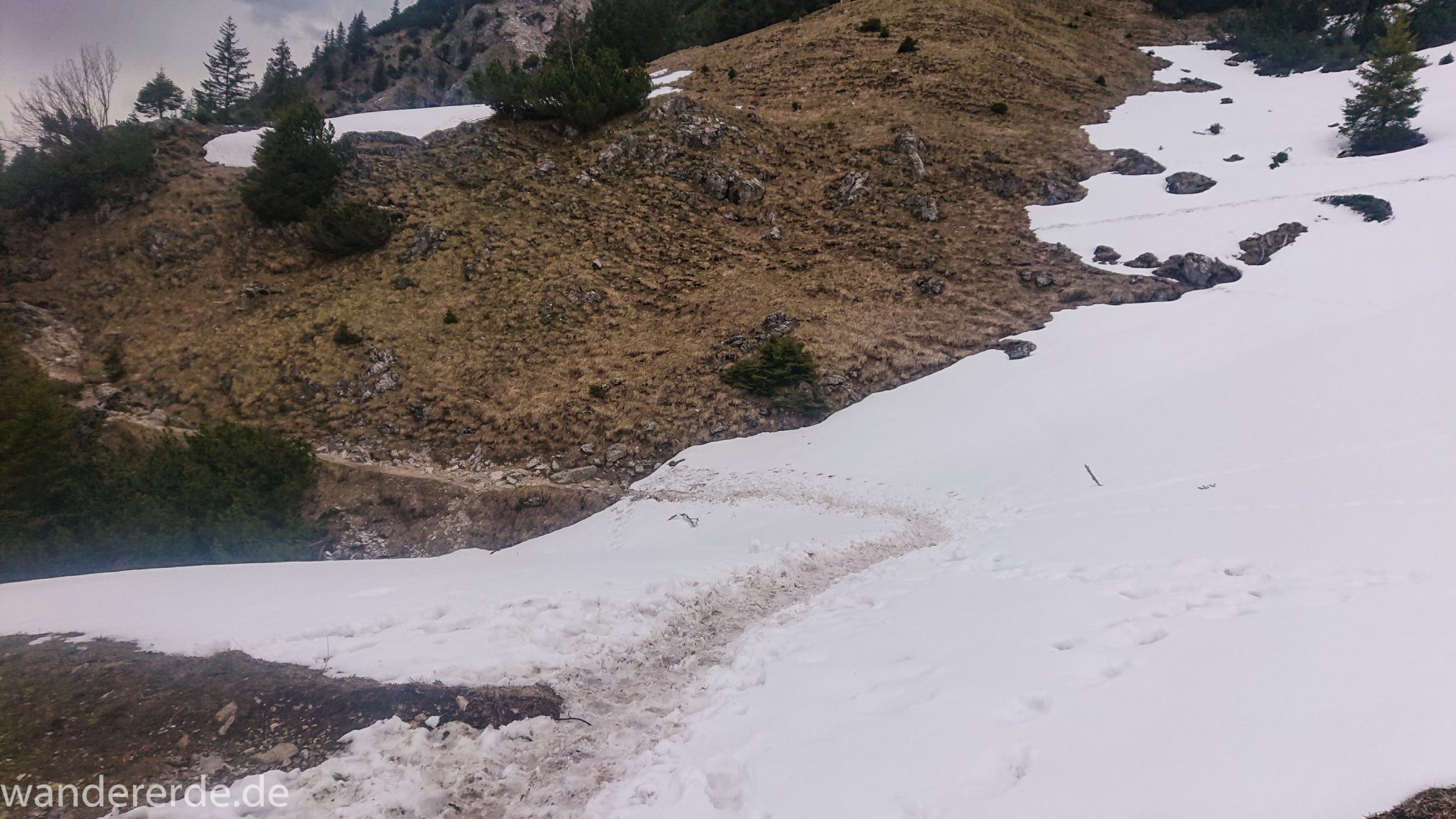 Wanderung Unterer Gaisalpsee, Wanderweg von Oberstdorf im Allgäu, Wanderpfad wird zunehmend schmaler, steil und felsig, weniger Bäume, Blick auf Allgäuer Berge mit Schnee, Unterer Gaisalpsee fast vollständig mit Eis und Schnee bedeckt, Wanderung zu Oberer Gaisalpsee nicht möglich Mitte Mai