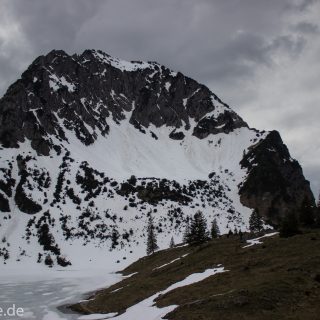 Wanderung Unterer Gaisalpsee, Wanderweg von Oberstdorf im Allgäu, Wanderpfad wird zunehmend schmaler, steil und felsig, weniger Bäume, Blick auf Allgäuer Berge mit Schnee und Unterer Gaisalpsee fast vollständig mit Eis und Schnee bedeckt, Wanderung zu Oberer Gaisalpsee nicht möglich Mitte Mai