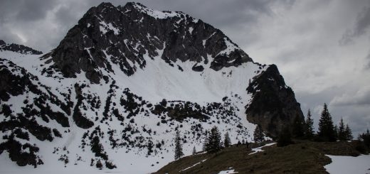 Wanderung Unterer Gaisalpsee, Wanderweg von Oberstdorf im Allgäu, Wanderpfad wird zunehmend schmaler, steil und felsig, weniger Bäume, Blick auf Allgäuer Berge mit Schnee und Unterer Gaisalpsee fast vollständig mit Eis und Schnee bedeckt, Wanderung zu Oberer Gaisalpsee nicht möglich Mitte Mai