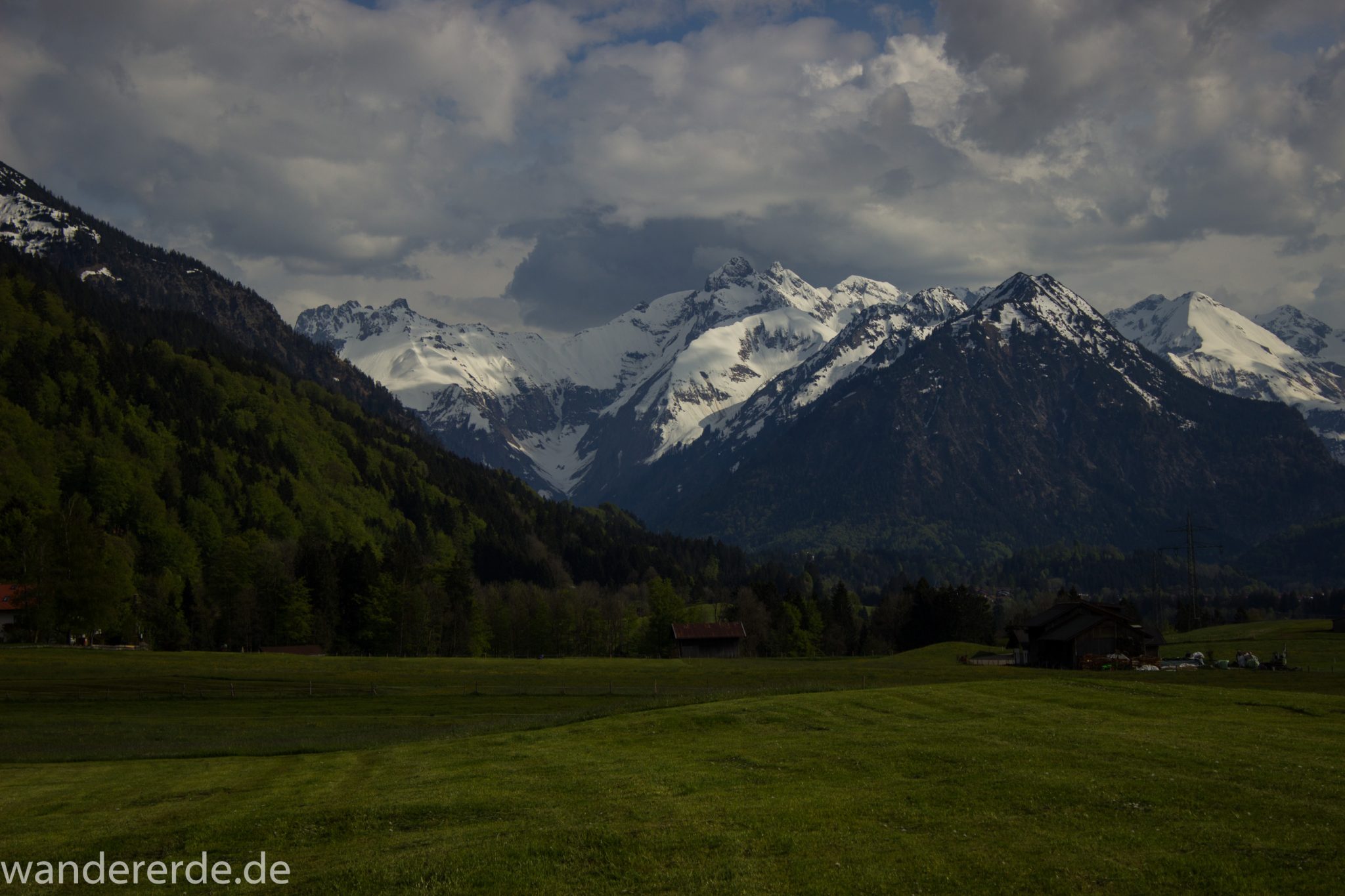 Wanderung Unterer Gaisalpsee, Abschnitt des Wanderwegs von Oberstdorf nach Fischen im Allgäu, Frühling im Allgäu, saftig grüne Wiesen, Blick auf Berge mit schneebedeckten Gipfeln