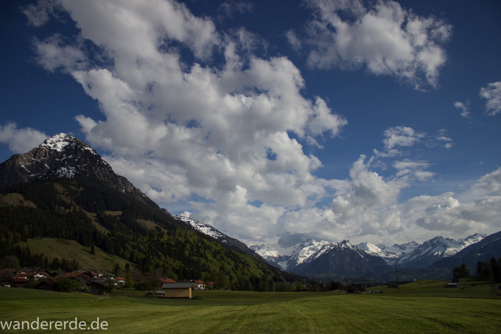 Wanderung Unterer Gaisalpsee, Abschnitt des Wanderwegs von Oberstdorf nach Fischen im Allgäu, Frühling im Allgäu, saftig grüne Wiesen, Blick auf Berge mit schneebedeckten Gipfeln
