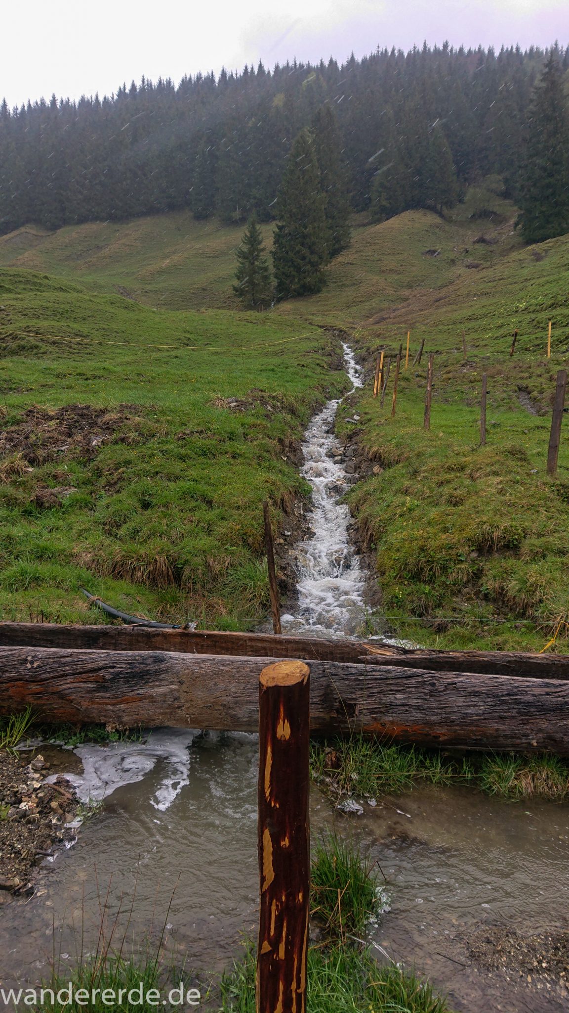 Wandern Gunzesrieder Ostertal im Allgäu, Baden-Württemberg, Obere Älple, viel Regen, dunkle Wolken, saftig grüne Wiesen und schöner Wald, Bach füllt sich durch viel Regen