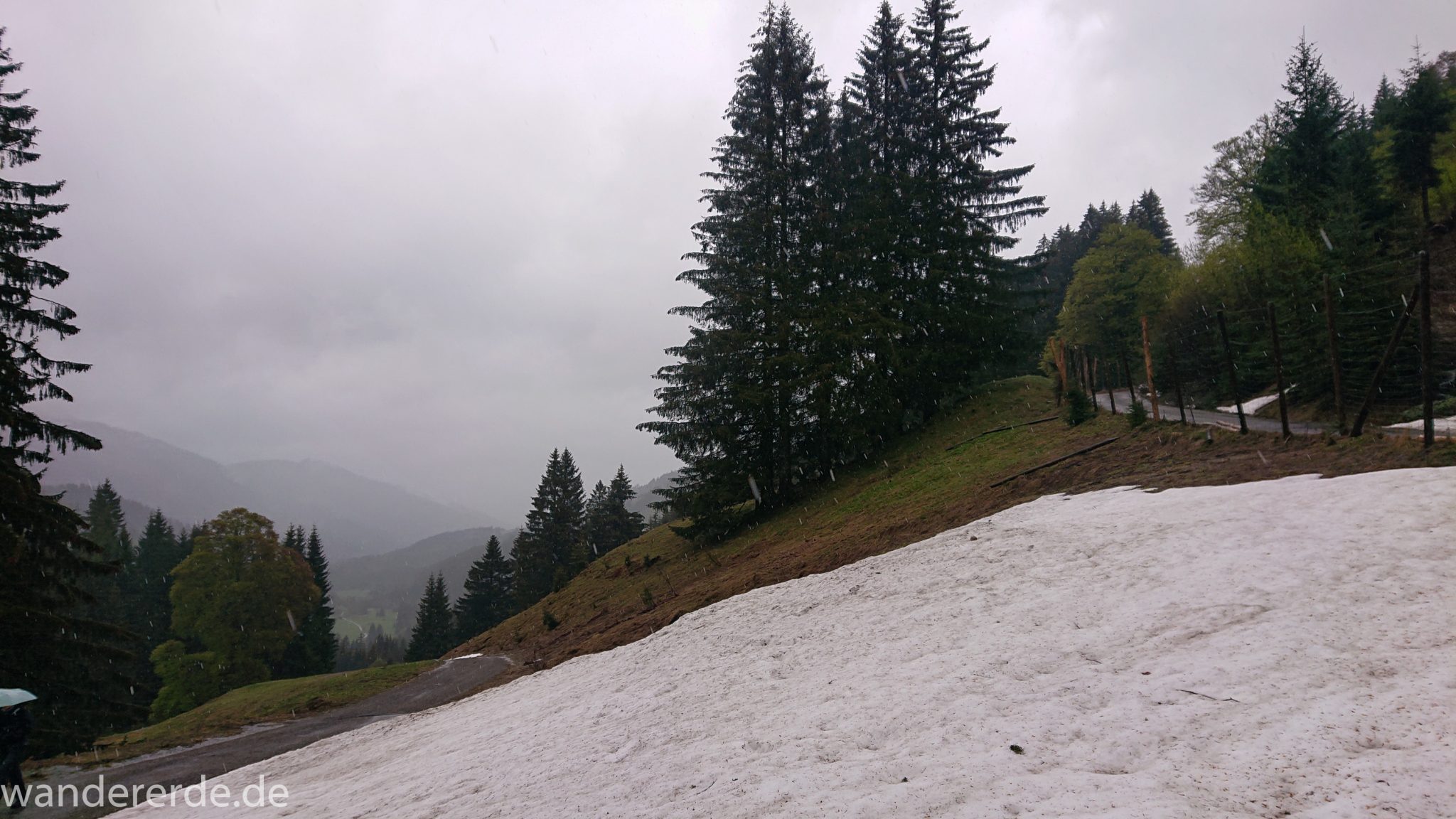 Wandern Gunzesrieder Ostertal im Allgäu, Baden-Württemberg, Obere Älple, viel Regen, dunkle Wolken, Schnee im Mai, Schneeschmelze, Wald, Wanderweg in Serpentinen bergauf