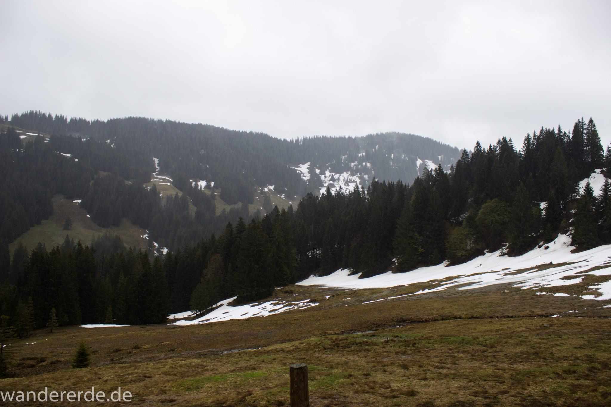 Wandern Gunzesrieder Ostertal im Allgäu, Baden-Württemberg, Obere Älple, viel Regen, dunkle Wolken, Schnee im Mai, saftig grüner Wald