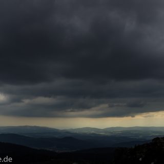 Rundwanderung zum Großen Arber im Bayerischen Wald, weite Aussicht auf riesiges Waldgebiet des bayerischen Waldes vom Berg Großer Arber, schöner und dichter Wald, Mischwald aus Laub- und Nadelbäume, Frühjahr im bayerischen Wald, sehr stimmungsvolles Licht durch dunkle Wolken und späten Tag