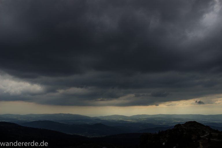 Rundwanderung zum Großen Arber im Bayerischen Wald, weite Aussicht auf riesiges Waldgebiet des bayerischen Waldes vom Berg Großer Arber, schöner und dichter Wald, Mischwald aus Laub- und Nadelbäume, Frühjahr im bayerischen Wald, sehr stimmungsvolles Licht durch dunkle Wolken und späten Tag
