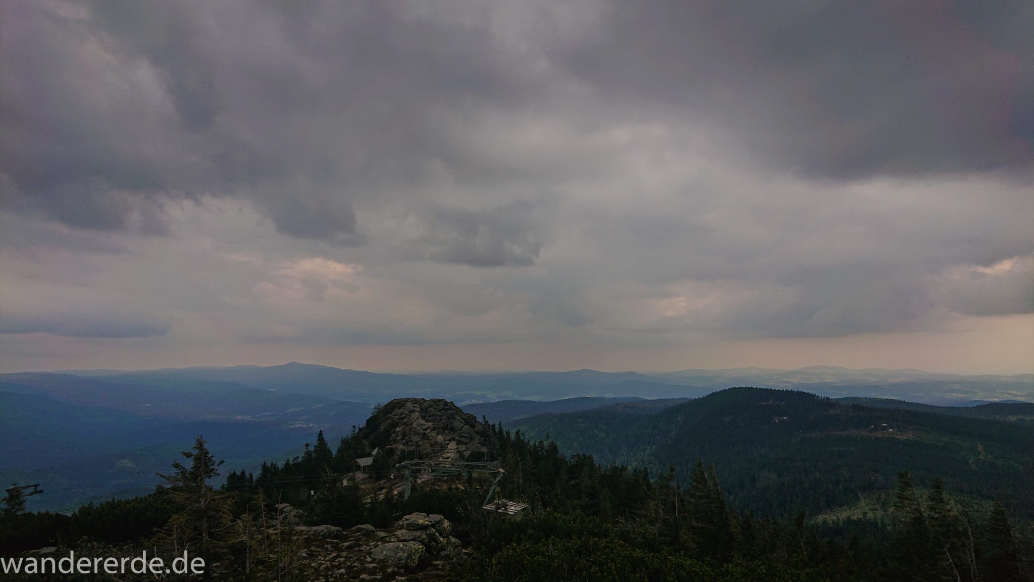 Rundwanderung zum Großen Arber im Bayerischen Wald, weite Aussicht auf riesiges Waldgebiet des bayerischen Waldes vom Berg Großer Arber, schöner und dichter Wald, Mischwald aus Laub- und Nadelbäume, Frühjahr im bayerischen Wald, sehr stimmungsvolles Licht durch dunkle Wolken und späten Tag