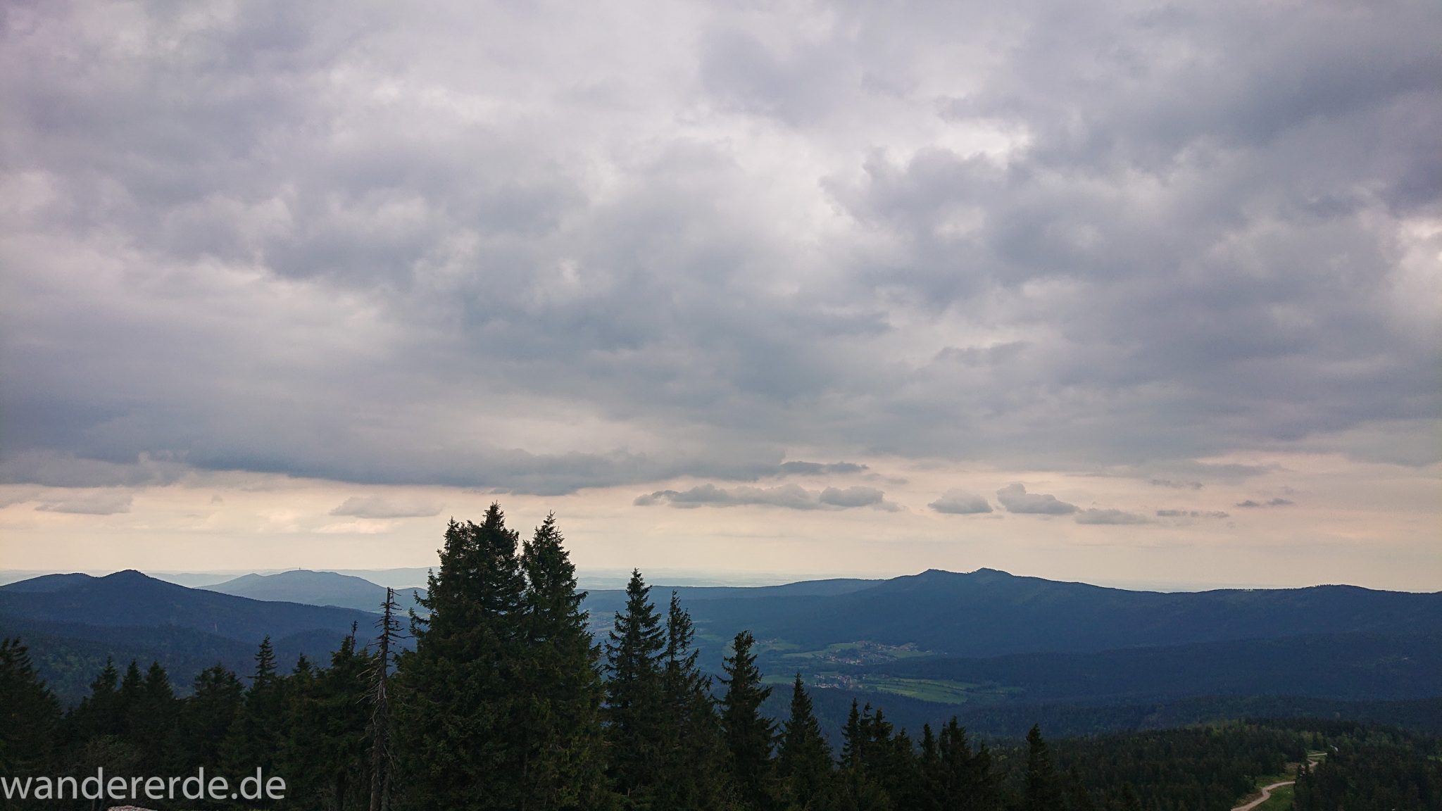 Rundwanderung zum Großen Arber im Bayerischen Wald, weite Aussicht auf riesiges Waldgebiet des bayerischen Waldes vom Berg Großer Arber, schöner und dichter Wald, Mischwald aus Laub- und Nadelbäume, Frühjahr im bayerischen Wald, sehr stimmungsvolles Licht durch dunkle Wolken und späten Tag