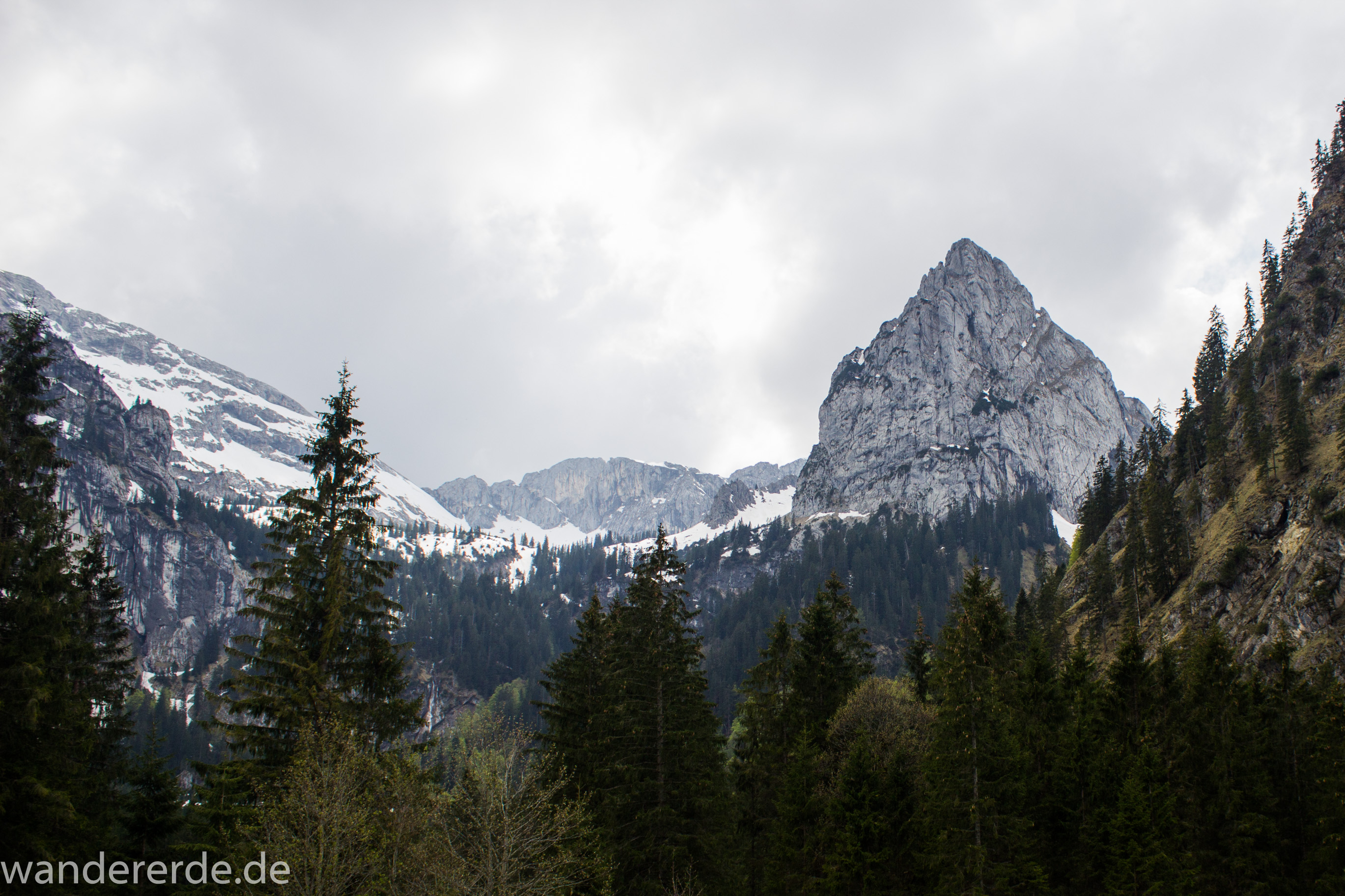 Wanderung zur Kenzenhütte in den Ammergauer Alpen, Aussicht auf die Berge, teils schneebedeckte Gipfel in Wolken gehüllt, Frühjahr in den bayerischen Alpen, dichter grüner Wald und saftige Wiesen, Wanderweg oftmals am schönen, idyllischem Bach entlang