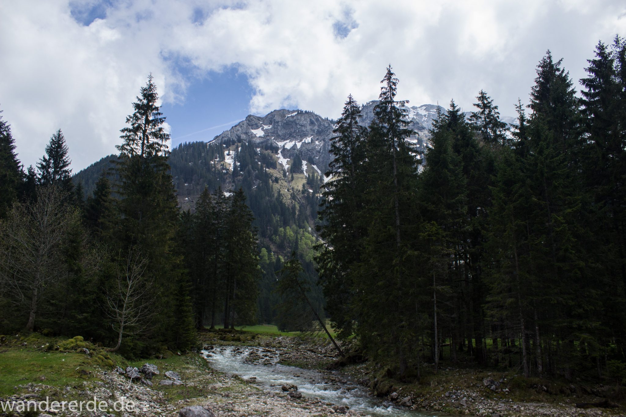 Wanderung zur Kenzenhütte in den Ammergauer Alpen, Aussicht auf die Berge, teils schneebedeckte Gipfel in Wolken gehüllt, Frühjahr in den bayerischen Alpen, dichter grüner Wald und saftige Wiesen, Wanderweg oftmals am schönen, idyllischem Bach entlang