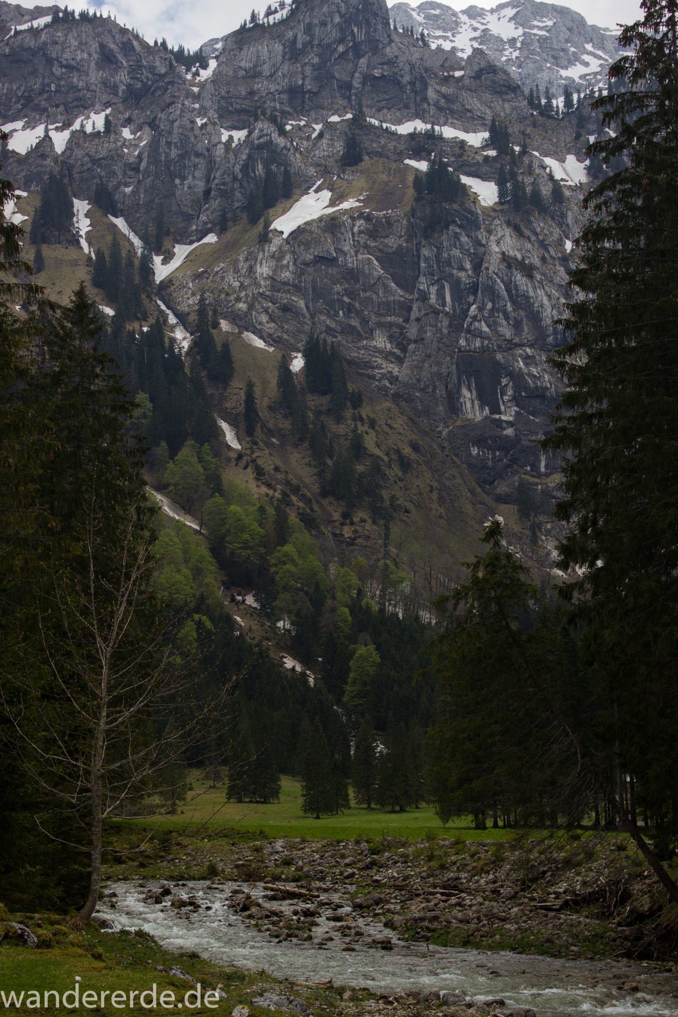 Wanderung zur Kenzenhütte in den Ammergauer Alpen, Aussicht auf die Berge, teils schneebedeckte Gipfel in Wolken gehüllt, Frühjahr in den bayerischen Alpen, dichter grüner Wald und saftige Wiesen, Wanderweg oftmals am schönen, idyllischem Bach entlang