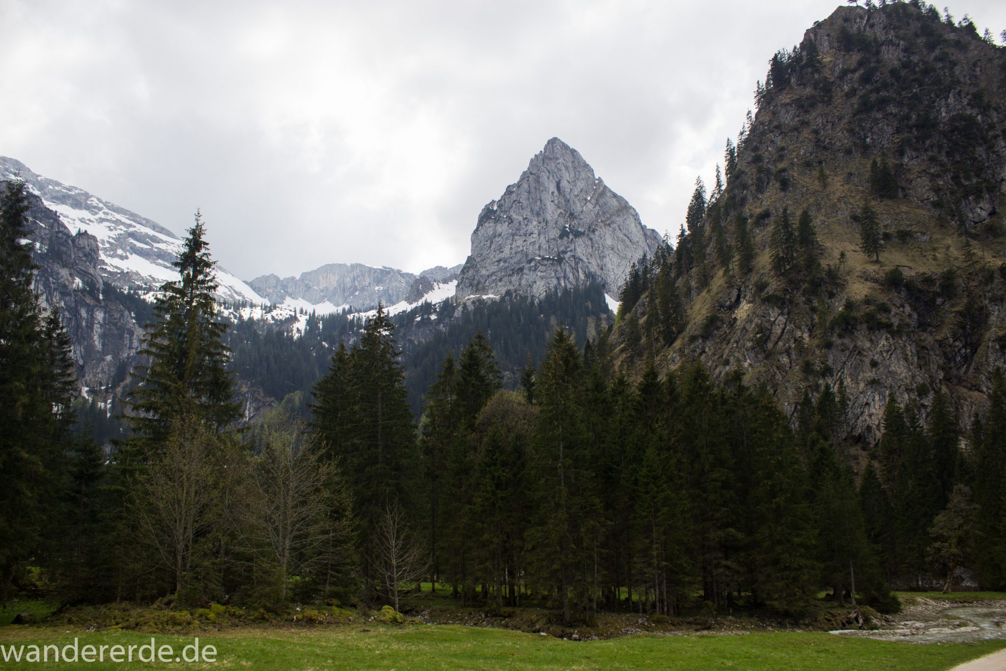 Wanderung zur Kenzenhütte in den Ammergauer Alpen, Aussicht auf die Berge, teils schneebedeckte Gipfel in Wolken gehüllt, Frühjahr in den bayerischen Alpen, dichter grüner Wald und saftige Wiesen, Wanderweg oftmals am schönen, idyllischem Bach entlang