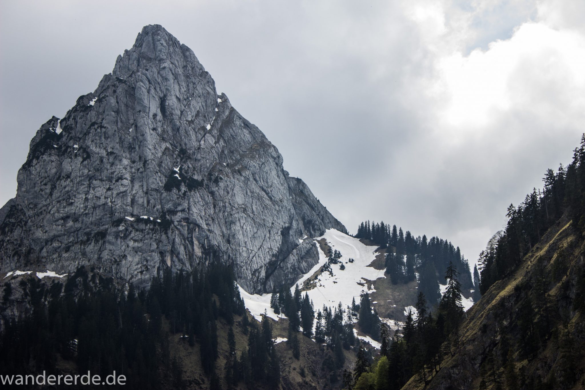 Wanderung zur Kenzenhütte in den Ammergauer Alpen, Aussicht auf die teils schneebedeckten Berge, spitzer Gipfel, Frühjahr in den bayerischen Alpen, sehr atmosphärisch durch dichte Wolkenfelder