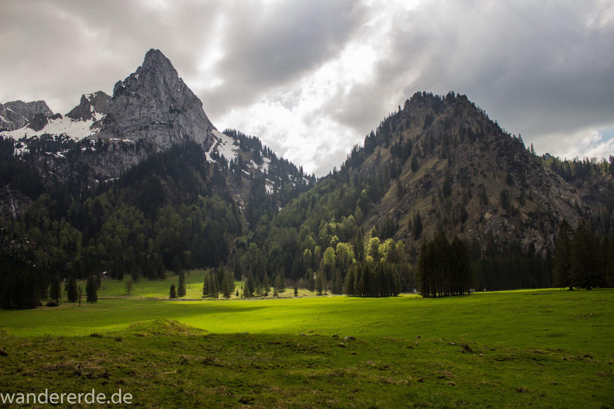 Wanderung zur Kenzenhütte in den Ammergauer Alpen, Aussicht auf die Berge, spitzer Gipfel, Frühjahr in den bayerischen Alpen, Wanderweg führt entlang dichtem grünen Wald und saftigen Wiesen
