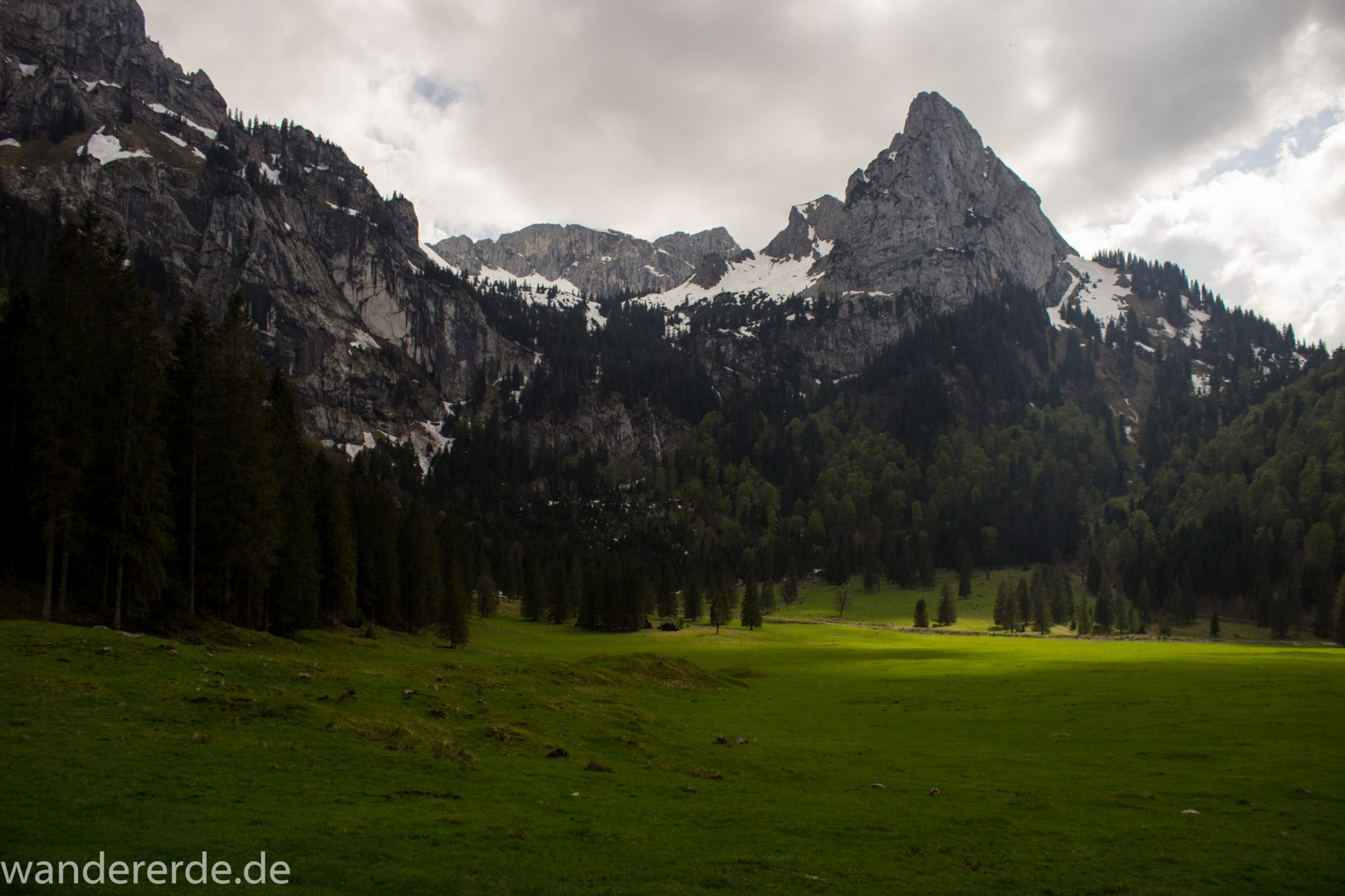 Wanderung zur Kenzenhütte in den Ammergauer Alpen, Aussicht auf die Berge, spitzer Gipfel, Frühjahr in den bayerischen Alpen, Wanderweg führt entlang dichtem grünen Wald und saftigen Wiesen