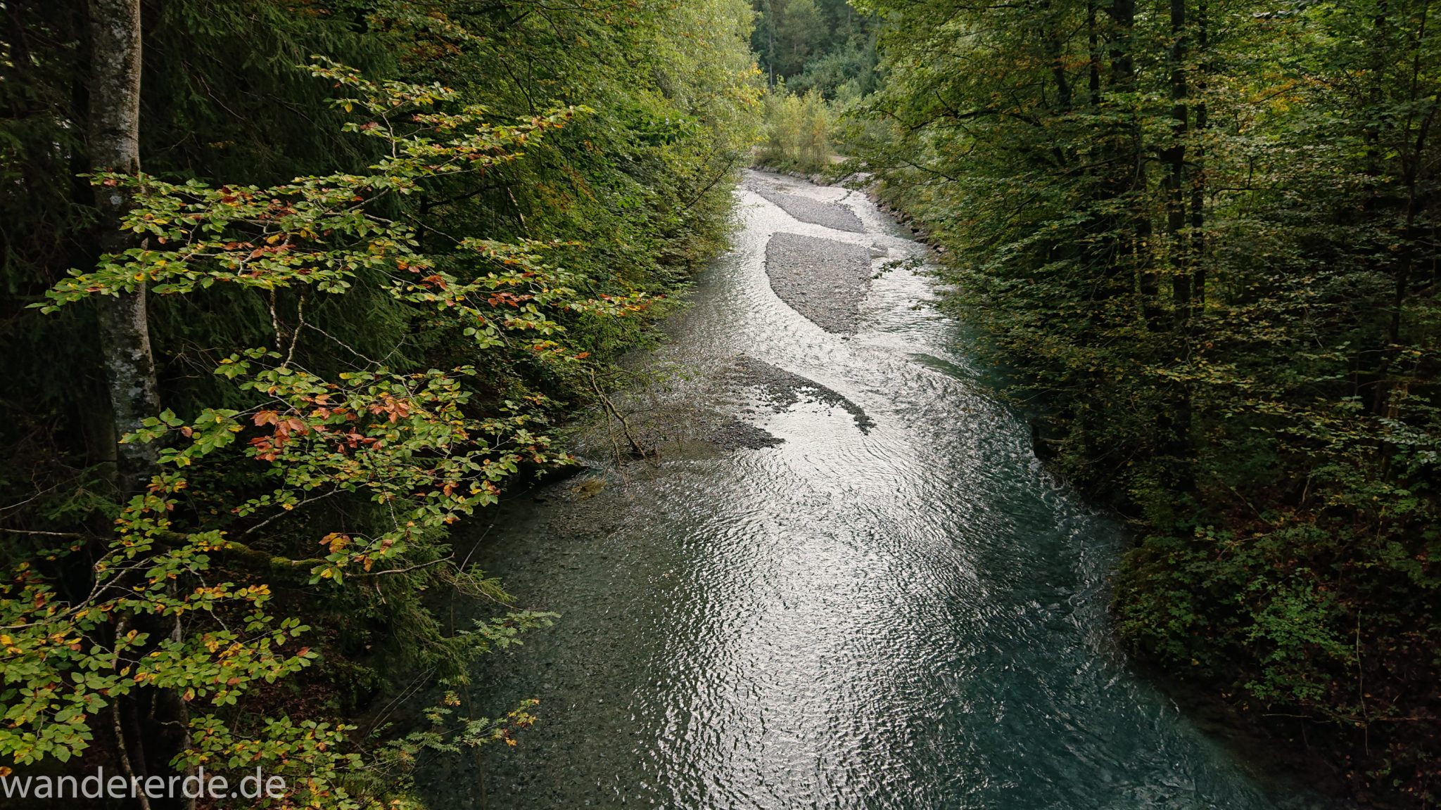 Alpenüberquerung Fernwanderweg E5 Oberstdorf Meran, 1. Etappe von Oberstdorf zur Kemptner Hütte, Wanderweg führt entlang am Fluss Trettach, Aussicht von einer Brücke umgeben von grünem Wald
