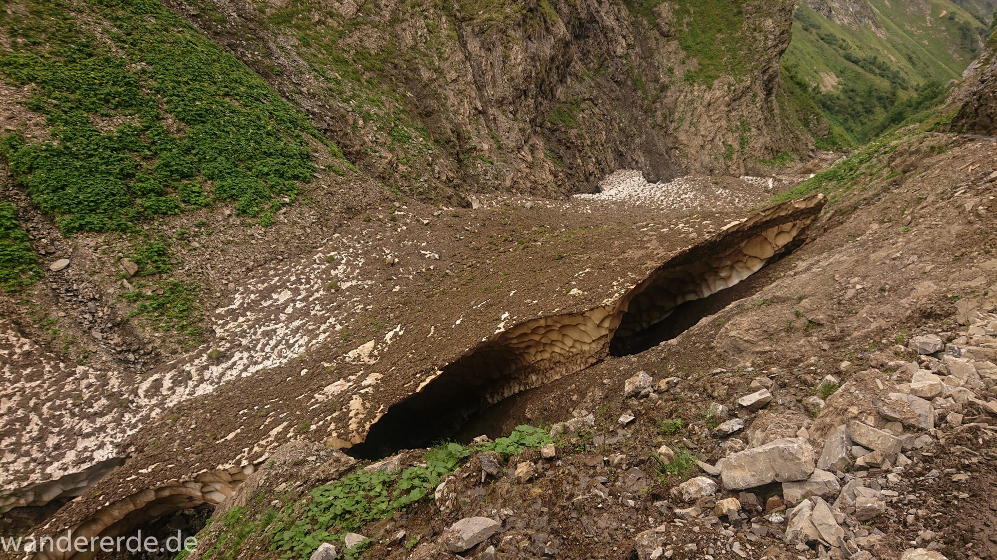 Alpenüberquerung Fernwanderweg E5 Oberstdorf Meran, 1. Etappe von Oberstdorf zur Kemptner Hütte, Wanderweg führt von der Spielmannsau bei Oberstdorf im Allgäu zur Kemptner Hütte entlang eines schmalen Wanderpfads über Stock und Stein, Weg durch Sperrbachtobel mit Schnee, Schlucht umgeben von hohen Felswänden in den Bergen, Wegverlauf zunehmend ansteigend, teilweise steil