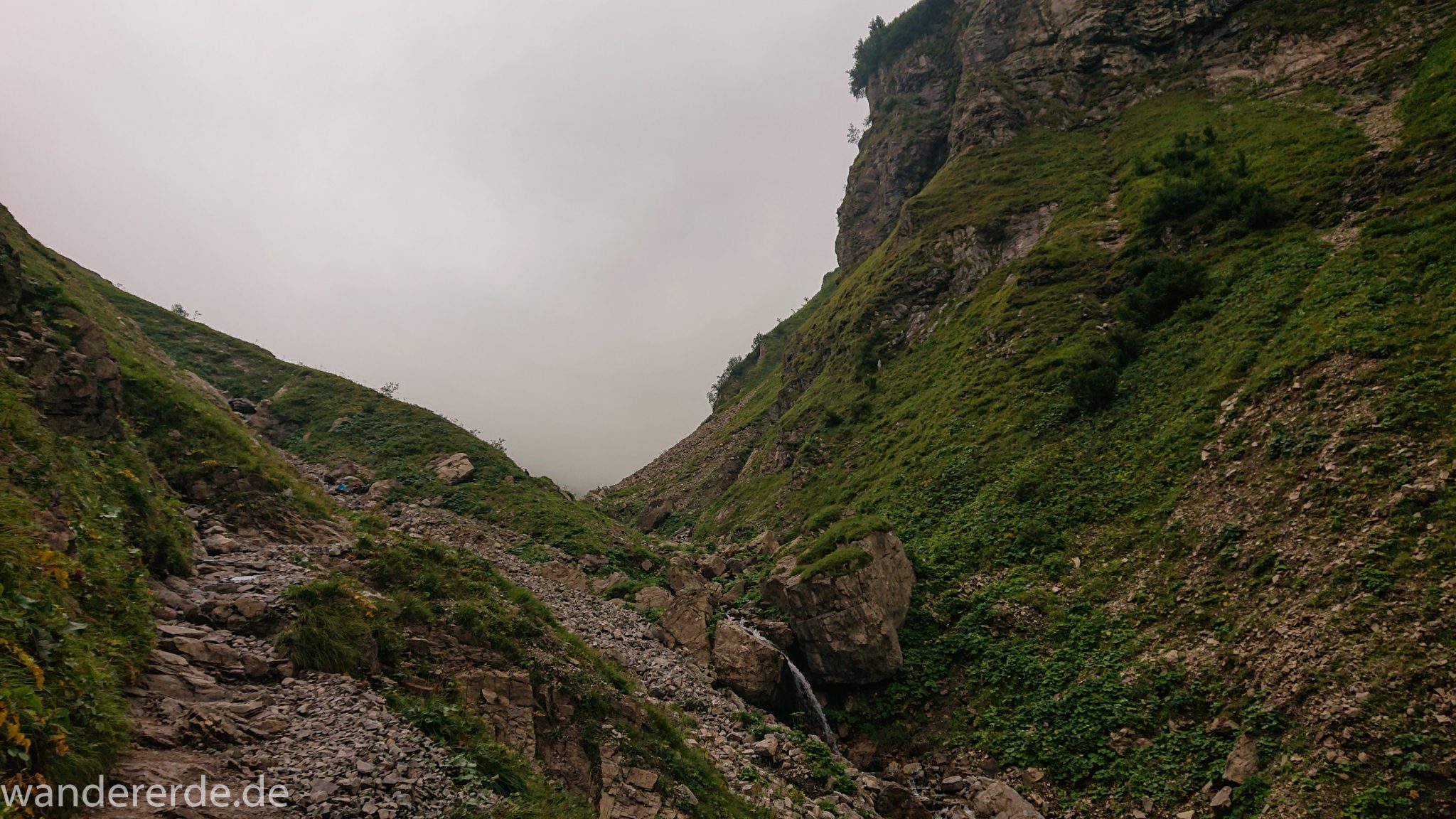 Alpenüberquerung Fernwanderweg E5 Oberstdorf Meran, 1. Etappe von Oberstdorf zur Kemptner Hütte, Wanderweg führt von der Spielmannsau bei Oberstdorf im Allgäu zur Kemptner Hütte entlang eines schmalen Wanderpfads über Stock und Stein, Weg durch Sperrbachtobel mit Schnee, Schlucht umgeben von hohen Felswänden in den Bergen, Wegverlauf zunehmend ansteigend, teilweise steil