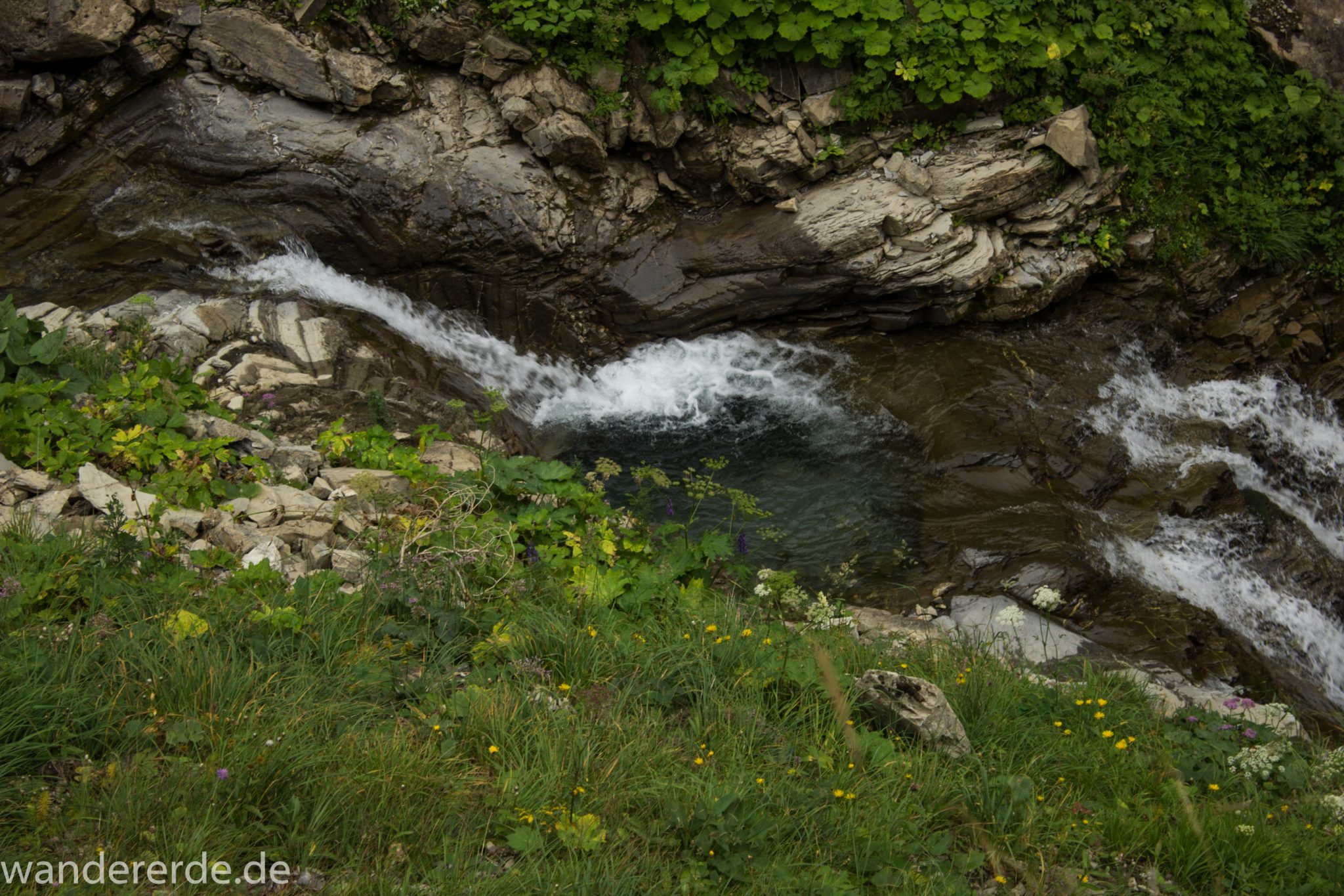 Alpenüberquerung Fernwanderweg E5 Oberstdorf Meran, 1. Etappe von Oberstdorf zur Kemptner Hütte, Wanderweg führt von der Spielmannsau bei Oberstdorf im Allgäu zur Kemptner Hütte entlang eines schmalen Wanderpfads über Stock und Stein, Weg durch Sperrbachtobel mit Schnee, Schlucht umgeben von hohen Felswänden in den Bergen, Wegverlauf zunehmend ansteigend, teilweise steil