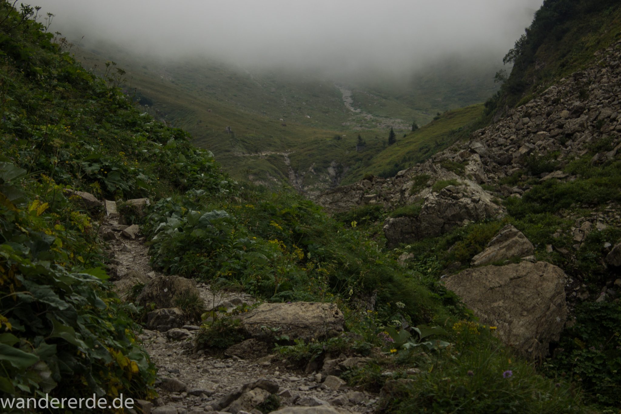 Alpenüberquerung Fernwanderweg E5 Oberstdorf Meran, 1. Etappe von Oberstdorf zur Kemptner Hütte, Wanderweg führt von der Spielmannsau bei Oberstdorf im Allgäu zur Kemptner Hütte entlang eines schmalen Wanderpfads mit saftig grüner Vegetation, über Stock und Stein, Weg durch Sperrbachtobel, Schlucht umgeben von hohen Felswänden in den Bergen, Wegverlauf zunehmend ansteigend, teilweise steil