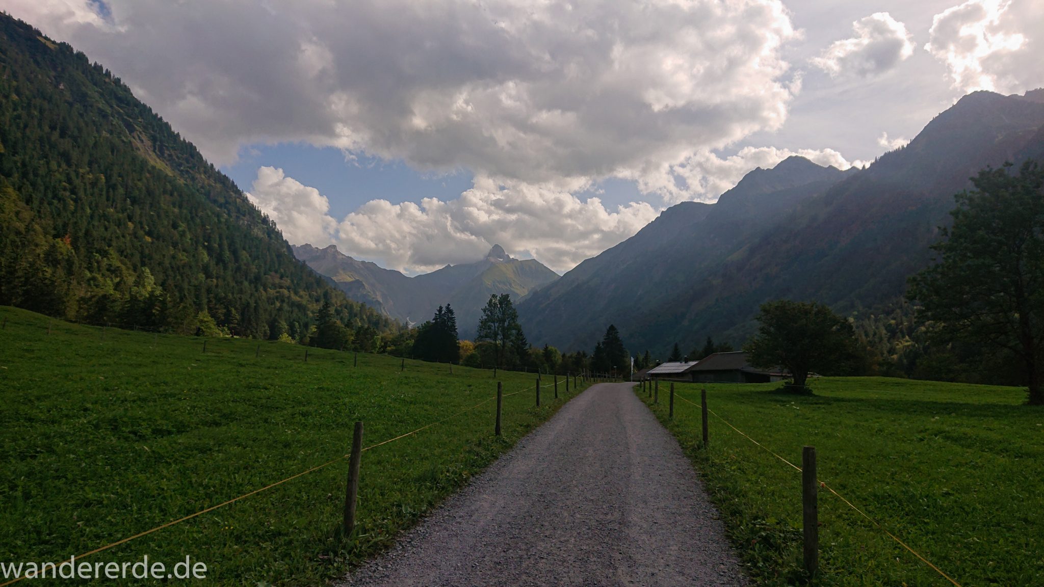 Alpenüberquerung Fernwanderweg E5 Oberstdorf Meran, 1. Etappe von Oberstdorf zur Kemptner Hütte, Wanderweg von Oberstdorf zur Spielmannsau führt entlang saftig grüner Wiesen im Allgäu umgeben von grünem Wald, Aussicht auf die Berge im Allgäu, Bayern