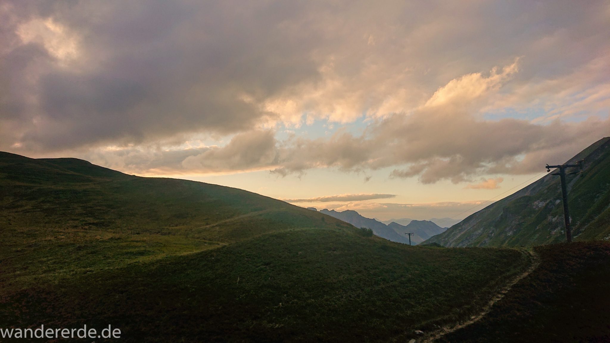 Alpenüberquerung Fernwanderweg E5 Oberstdorf Meran, 1. Etappe von Oberstdorf zur Kemptner Hütte, Ausblick bei der Kemptner Hütte auf die umliegenden schönen Berge, teilweise in Wolken gehüllt, grüne Wiesen im Allgäu, kurz vor Sonnenuntergang