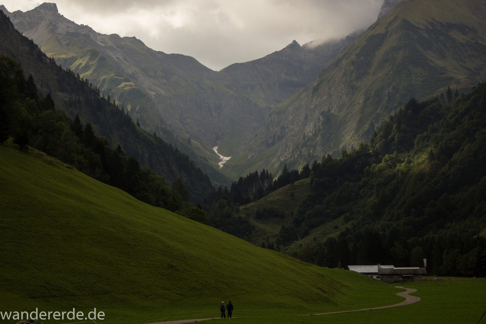 Alpenüberquerung Fernwanderweg E5 Oberstdorf Meran, 1. Etappe von Oberstdorf zur Kemptner Hütte, Wanderweg von Oberstdorf zur Spielmannsau führt entlang saftig grüner Wiesen im Allgäu umgeben von grünem Wald, Aussicht auf die Berge im Allgäu, Bayern