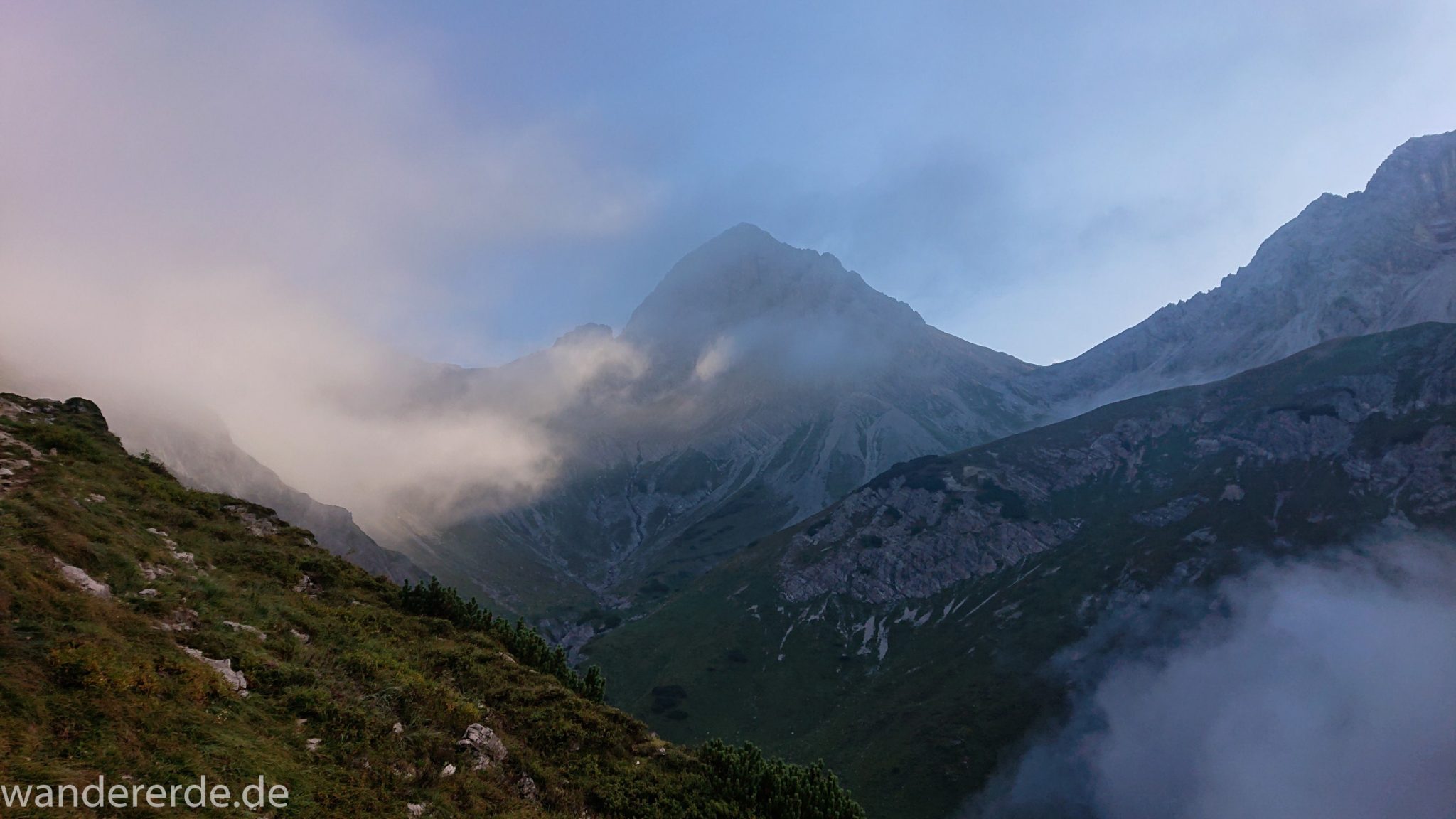 Alpenüberquerung Fernwanderweg E5 Oberstdorf Meran, 2. Etappe von Kemptner Hütte zur Memminger Hütte, in der Nähe vom Mädelejoch, umliegende Berge in Wolken gehüllt, Berggipfel nur teilweise sichtbar, Wanderung mit eingeschränkter Sicht wegen Nebel, beeindruckende Landschaft in den Bergen, bezaubernde Alpen